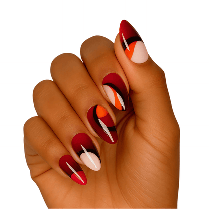 Hand wearing red and orange abstract gel nail wraps with glossy finish