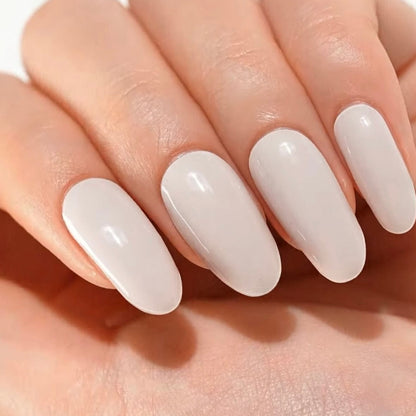 Glossy white oval gel nails on hand showing classic bridal nail art finish