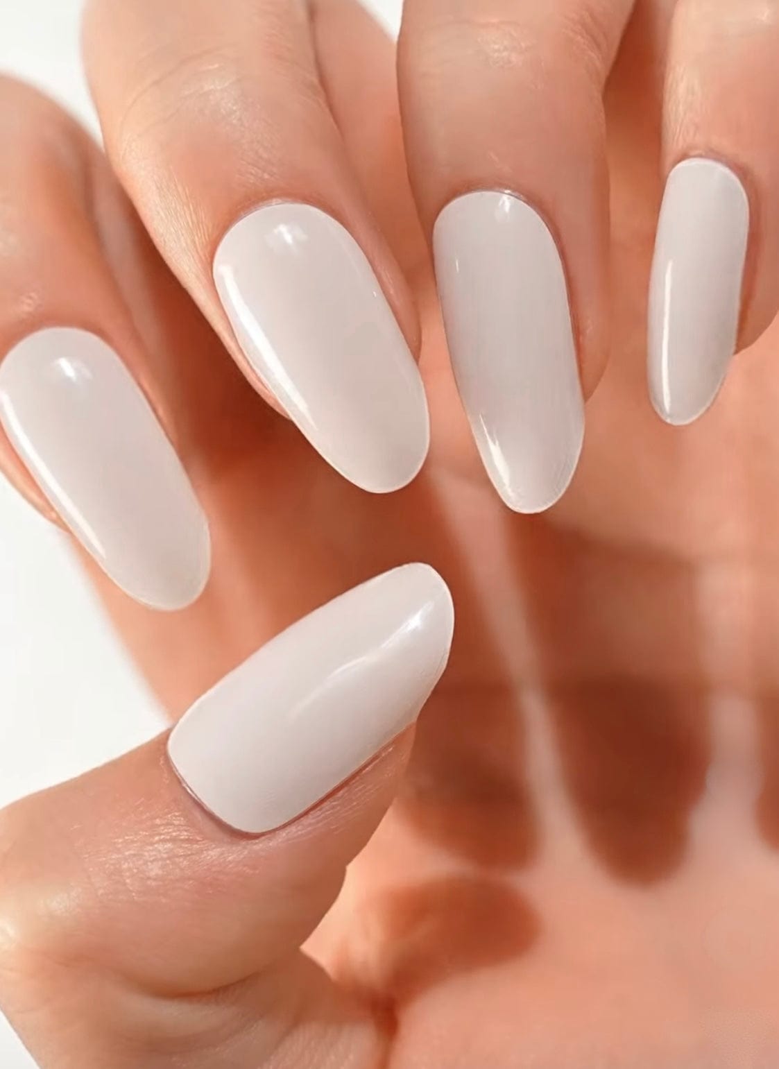 Glossy ivory white gel nail wraps on hand showing elegant bridal manicure