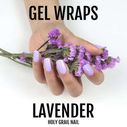 Hand holding purple flowers wearing lavender gel nail wraps for at-home manicure
