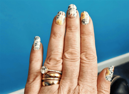 Hand wearing floral gel nail wraps with vintage botanical design in pastel colours