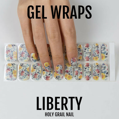 Hand holding floral gel nail wraps showing botanical pattern with multicoloured vintage flowers