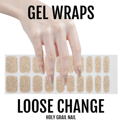 Hand displaying champagne gold glitter gel nail wraps in metallic finish for elegant manicure