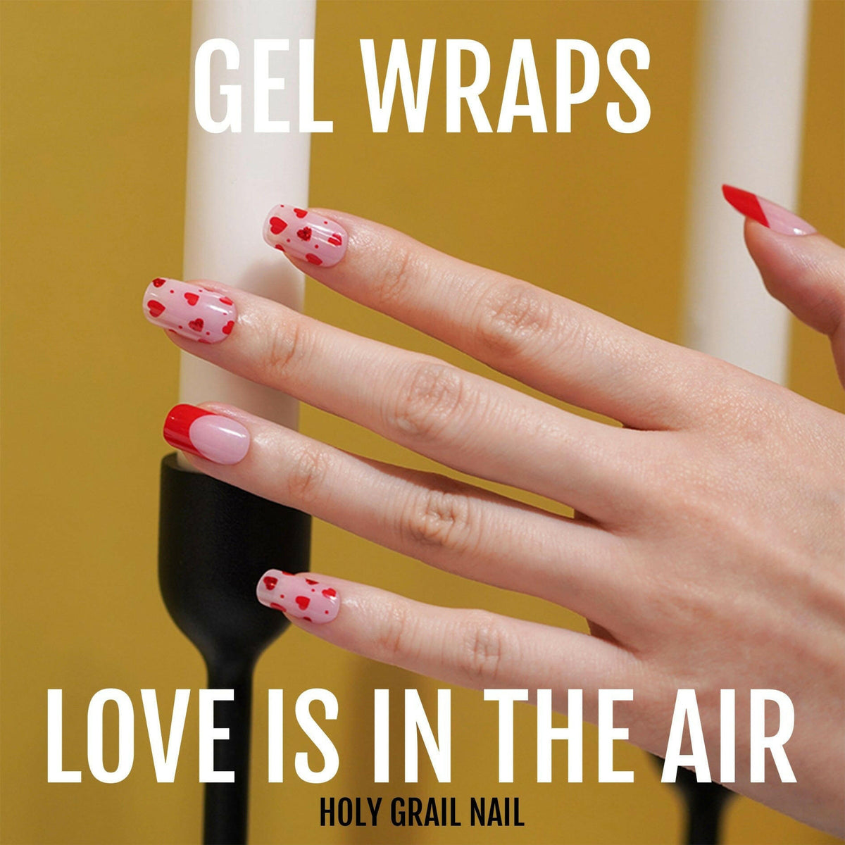 Red and pink heart pattern gel nail wraps on hand for Valentine's manicure