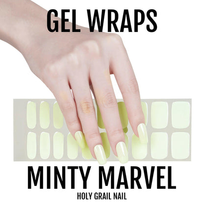 Hand showing mint green gel nail wraps with product sheet for DIY manicure