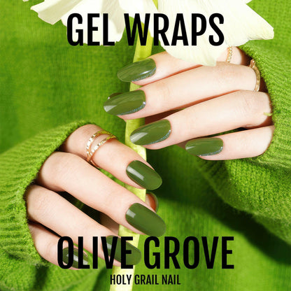 Hand wearing olive green glossy gel nail wraps against lime green knit jumper backdrop