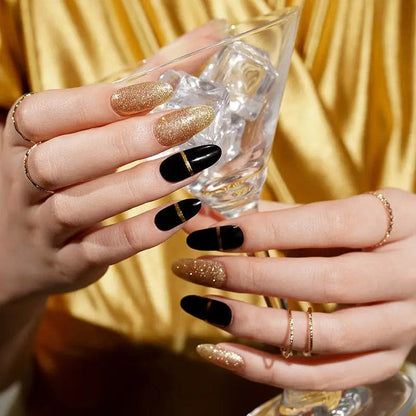 Woman holding champagne glass showing black and gold glitter gel nails for celebrations