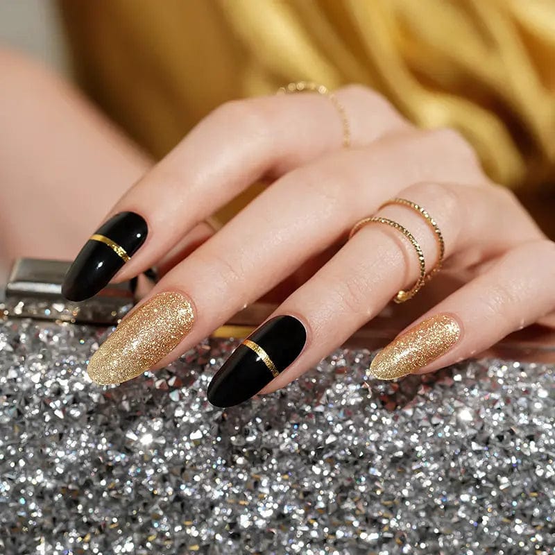 Glamorous black and gold gel nails on hand with glittery metallic accent nails