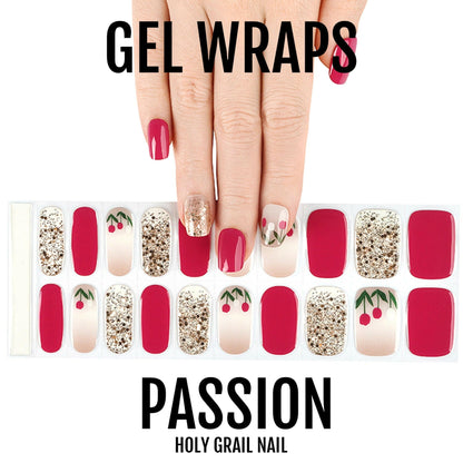 Red gel nail wraps with gold glitter and floral patterns on hand showing at-home manicure