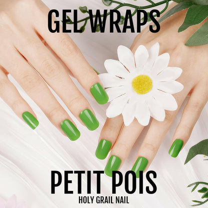 Green gel nail wraps on hands with white daisy and natural greenery styling