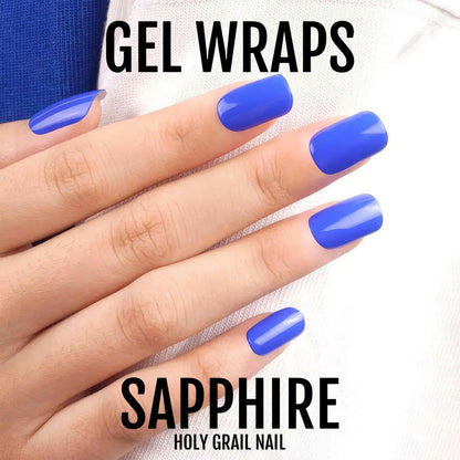 Sapphire blue gel nail wraps on hand displaying bold glossy finish for at-home manicure