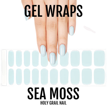 Pale sage-grey semi-cured gel nail wraps with a glossy solid-colour finish, shown on hand and sheet