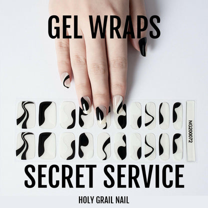 Hand wearing black abstract curve gel nail wraps showing minimalist monochrome nail art design