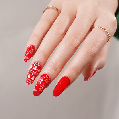 Hand displaying red Christmas gel nail wraps with white festive patterns and glossy finish
