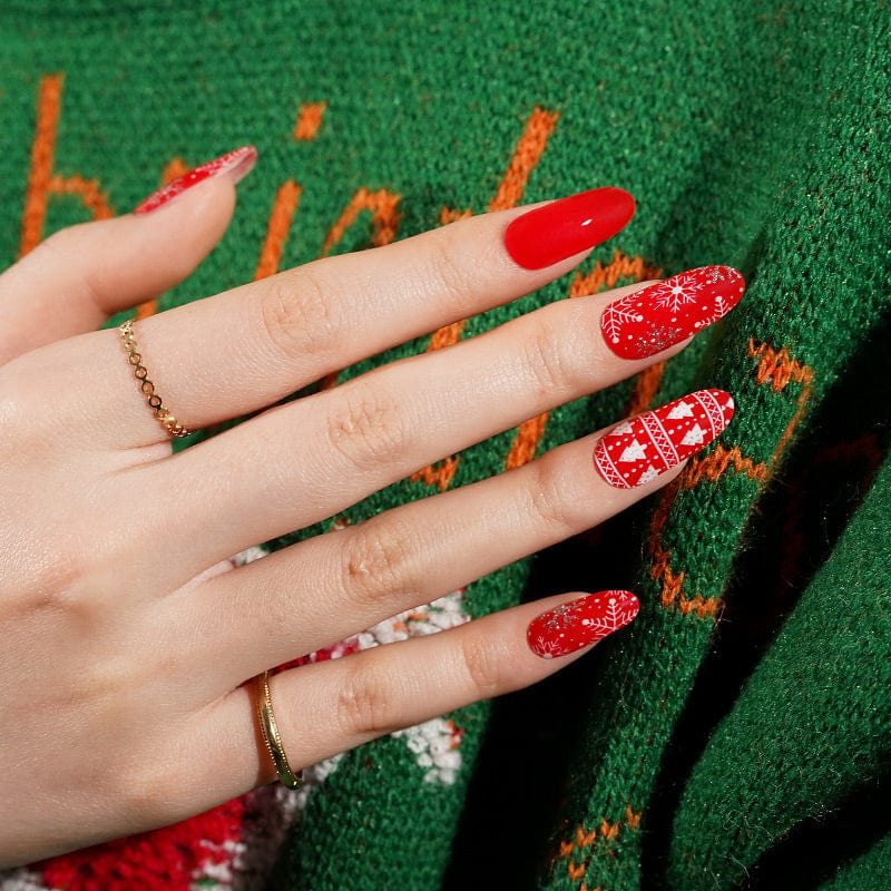 Red Christmas gel nail wraps with white reindeer patterns and glitter accents on hand