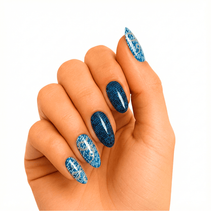 Blue snake print gel nail wraps on hand showing glossy navy and silver animal pattern
