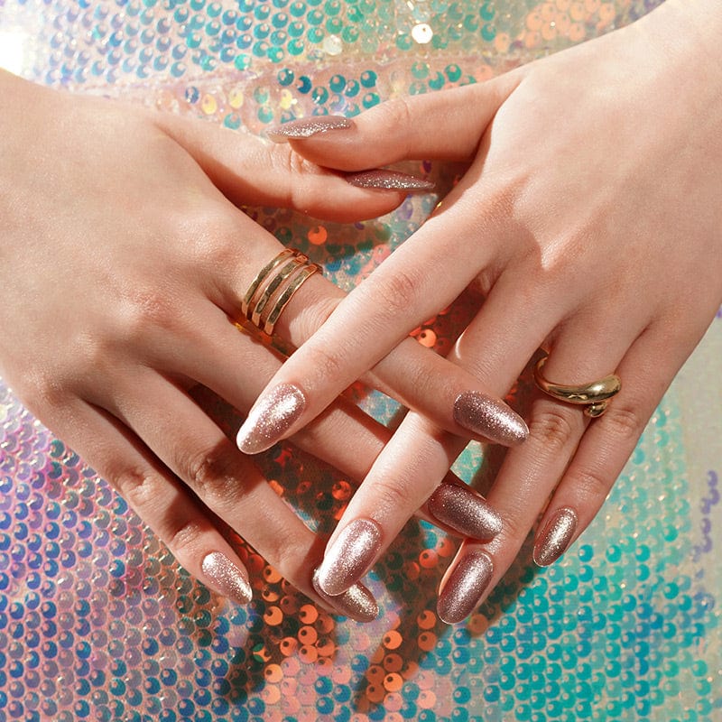 Hands wearing rose gold glitter gel nail wraps with holographic rainbow background accent