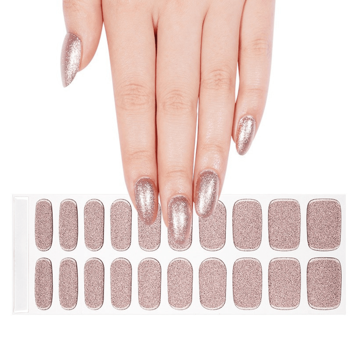 Hand with rose gold gel nail wraps beside full sheet of glitter nail art wraps