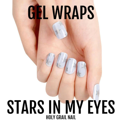 Periwinkle blue gel nail wraps with glitter stars on manicured hand fingers