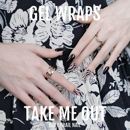 Two hands showing black and white diagonal striped gel nail wraps on floral background