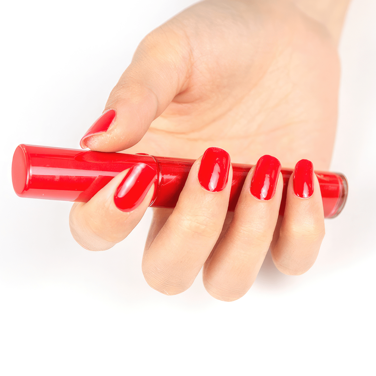 Hand holding red gel nail wrap strip demonstrating glossy crimson nail art