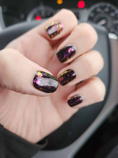 Black rainbow holographic gel nail wraps on hand with sparkly glitter effect