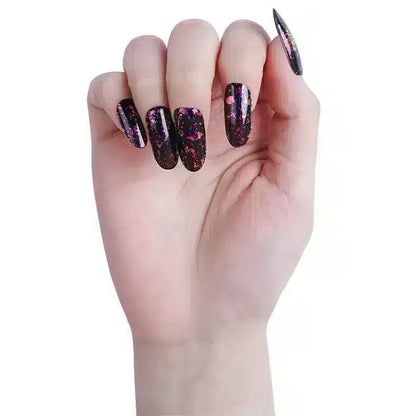 Hand wearing dark holographic gel nail wraps with rainbow glitter and metallic sparkles