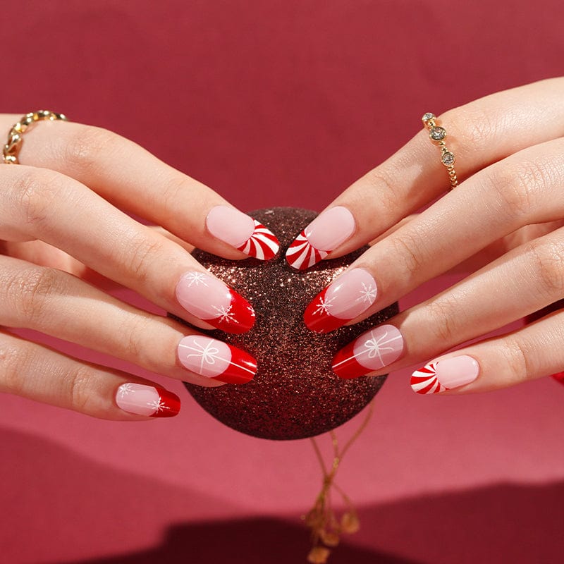 Holiday gel nail wraps with red French tips and white snowflake designs on hands