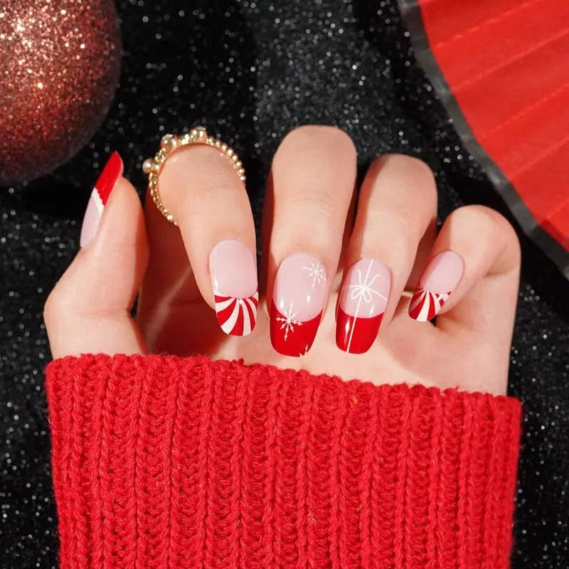 Red and pink Christmas French tip gel nail wraps with white snowflake patterns on hand