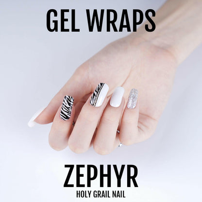 Zebra print gel nail wraps on hand with black stripes white and glitter designs