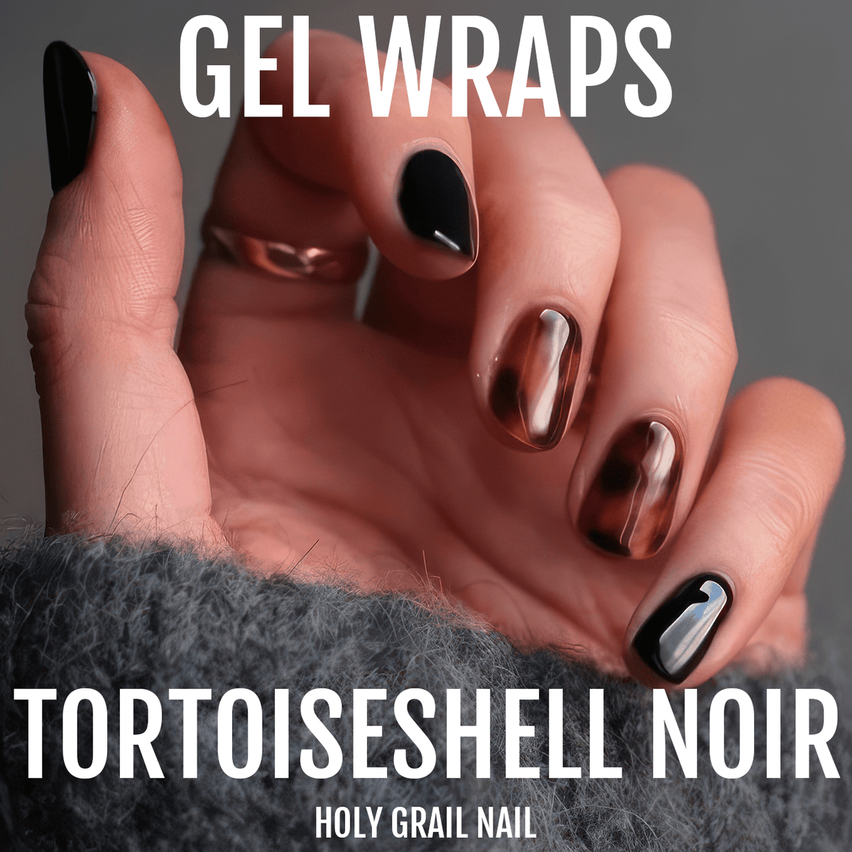 Hand wearing tortoiseshell gel nail wraps with black and brown marbled finish