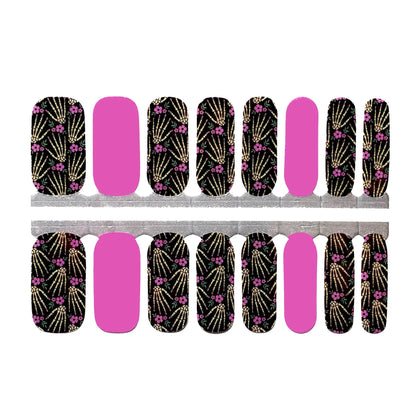 Black nail wraps with pink floral skeleton hands print, paired with solid pink accent nails