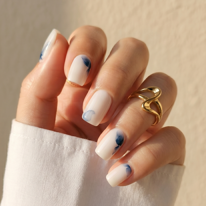 Short square press-on nails, milky white base with abstract navy blue watercolour accents